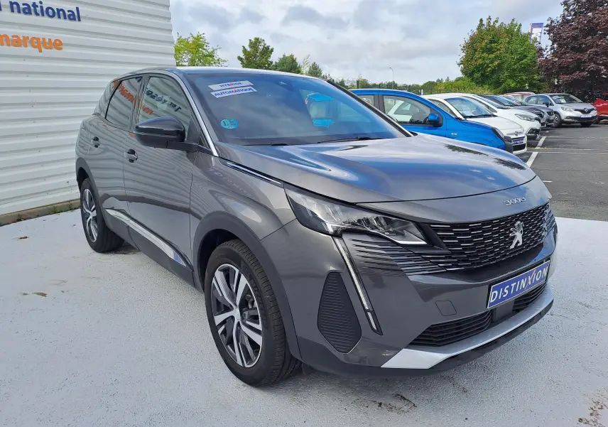 Peugeot 3008 gris platinium en 3/4 avant droit, avec calandre distinctive et feux LED modernes visibles.