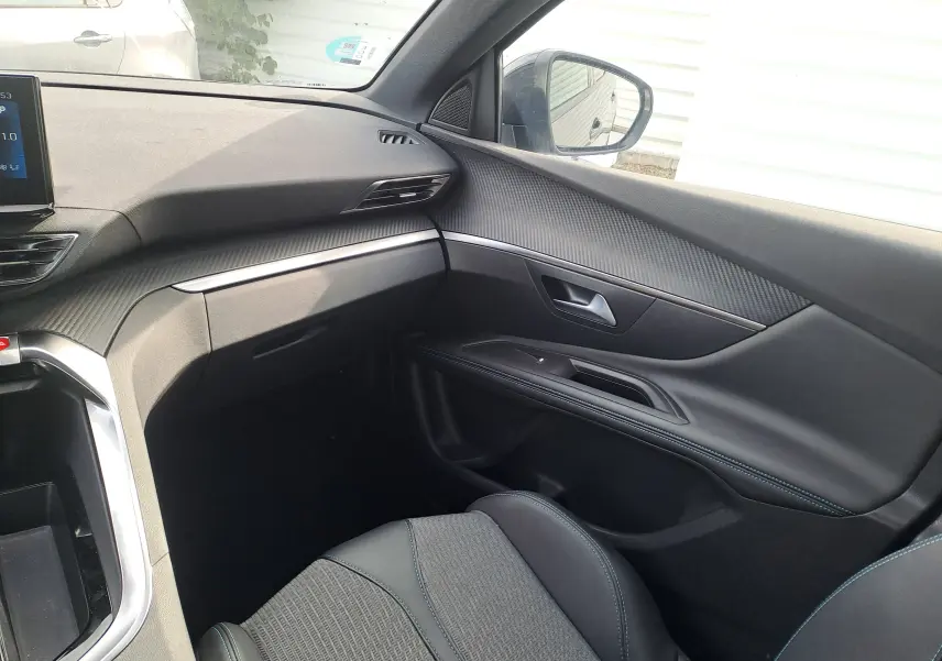 Vue intérieure côté passager du Peugeot 3008 Hybrid 145 Allure Pack 2024, avec sellerie noire et finitions modernes.