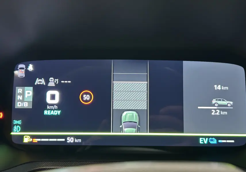 Tableau de bord numérique du Dacia Bigster affichant la vitesse, la consommation et l'assistance au stationnement en vue centrale.