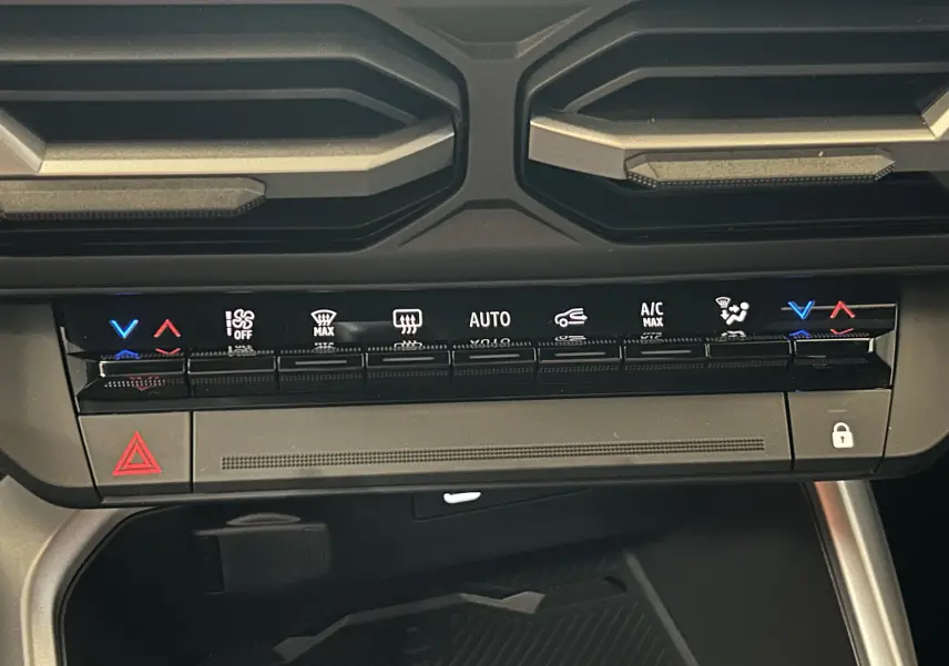 Détail du tableau de bord du Dacia Bigster 2026 noir nacré, montrant les commandes de climatisation et les aérateurs supérieurs.