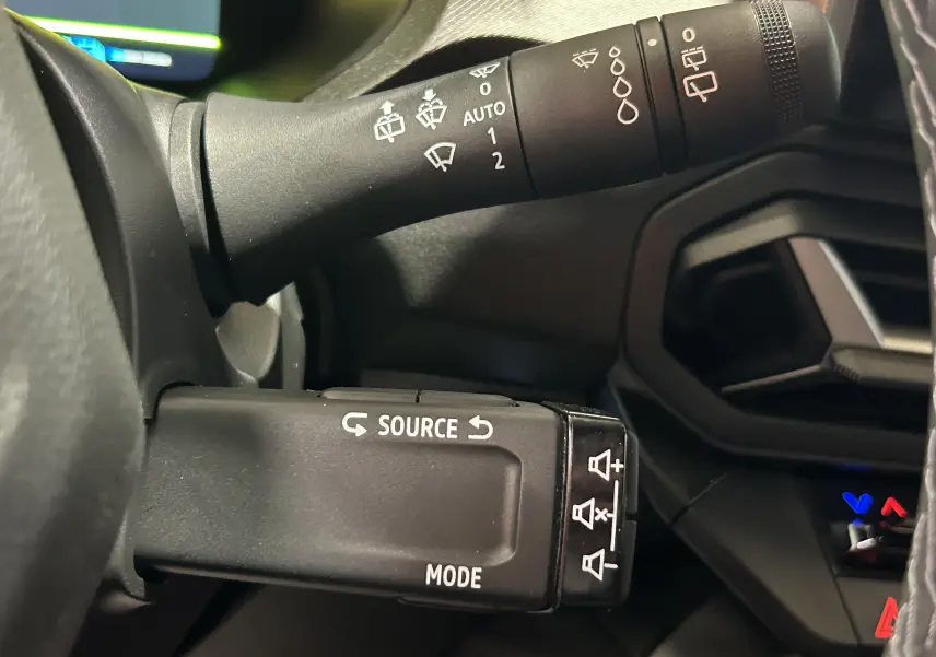 Gros plan sur les commandes au volant du Dacia Bigster 2026, finition noire, avec commandes multimédia et essuie-glace.