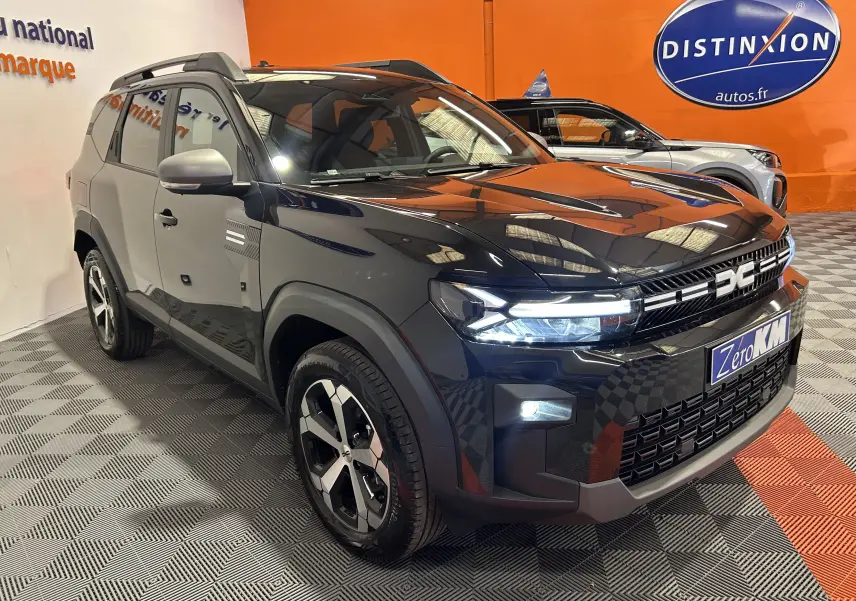 Vue 3/4 avant d'un Dacia Bigster noir nacré avec calandre marquée et jantes bicolores en concession.