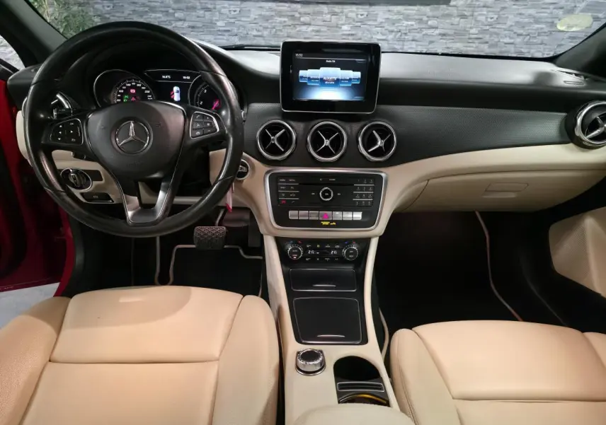 Intérieur beige et noir de Mercedes GLA 200 d 2017, vue de face sur le tableau de bord et volant multifonctions cuir.