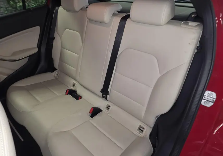 Vue intérieure arrière côté droit montrant la banquette beige clair du Mercedes GLA 200 d rouge avec ceinture noire.