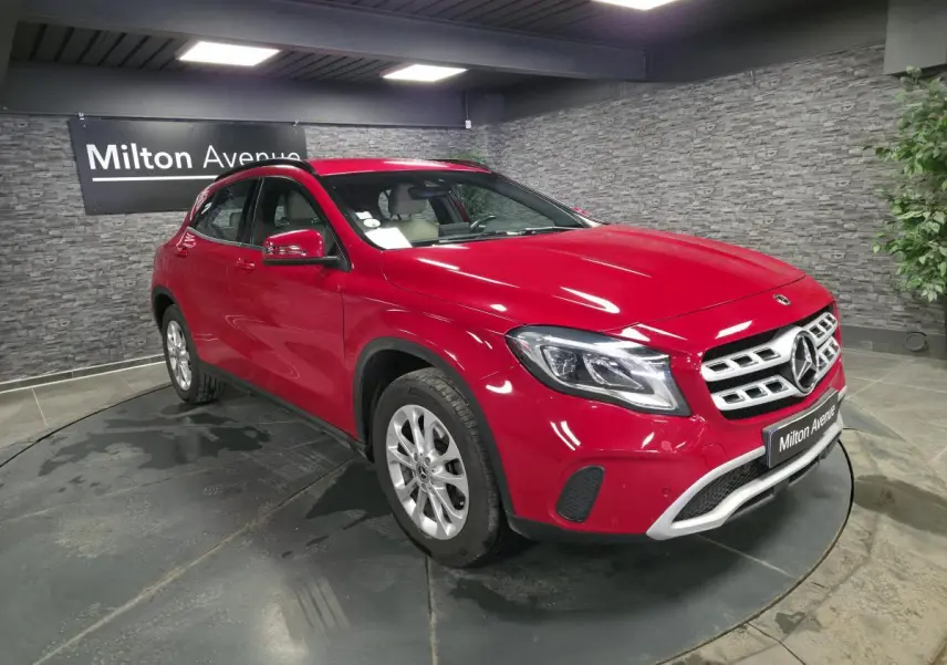 Mercedes GLA 200 d rouge vue 3/4 avant droit, avec jantes alliage argent et calandre chromée, en showroom.