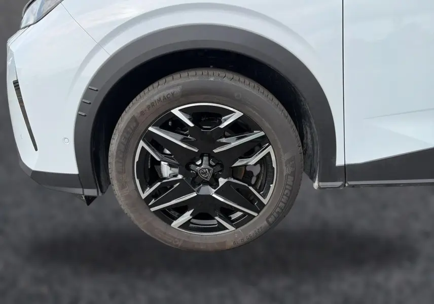 Gros plan sur la roue avant droite noire et argentée du Peugeot 3008 blanc, soulignant la jante alu distinctive.