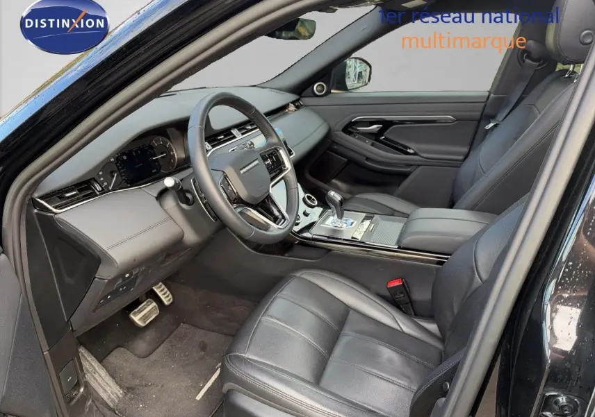 Vue intérieure côté conducteur du Range Rover Evoque 2023 noir Santorini, avec sièges cuir et tableau de bord moderne.