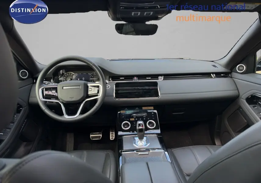 Vue intérieure avant du Range Rover Evoque 2023 en Santorini Black, avec tableau de bord moderne et console centrale tactile.