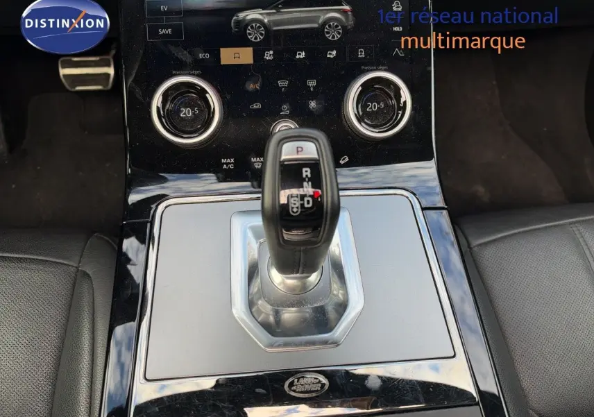 Vue rapprochée de la console centrale du Range Rover Evoque 2023 Santorini Black, avec levier de vitesses automatique et écran tactile.