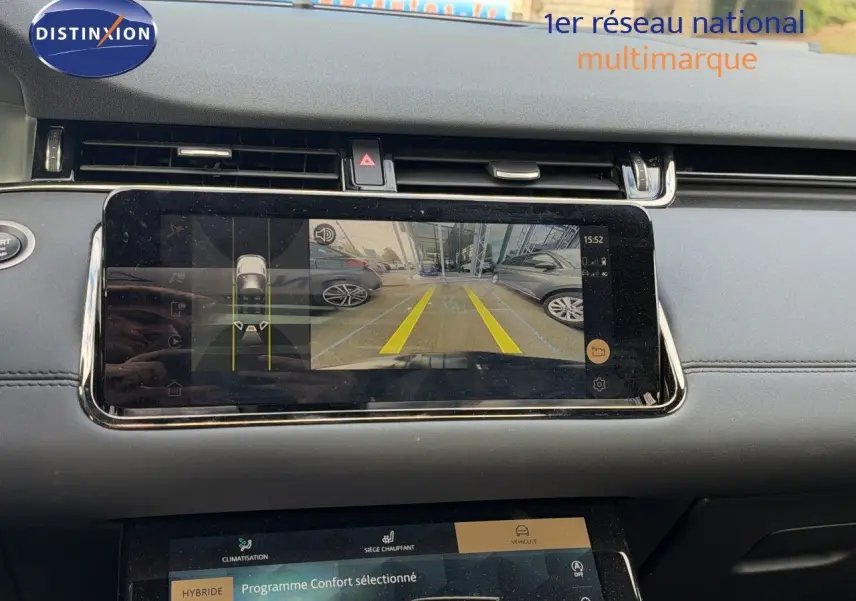 Vue intérieure du tableau de bord du Range Rover Evoque 2023 noir, avec écran affichant la caméra de recul et les réglages du programme confort hybride.
