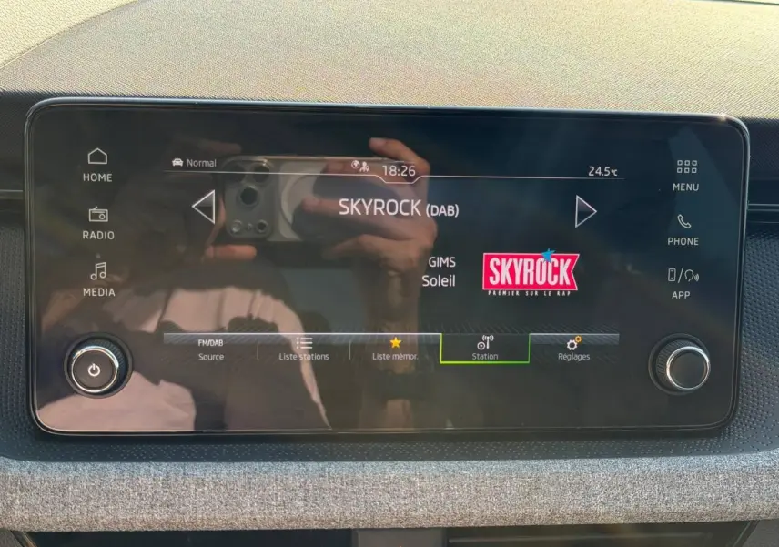 Écran tactile central de la Skoda Scala gris, affichant la radio numérique Skyrock en mode FM/DAB.