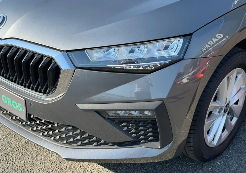 Gros plan sur l'avant droit gris métallisé d'une Skoda Scala 2025 avec calandre chromée et phares LED.