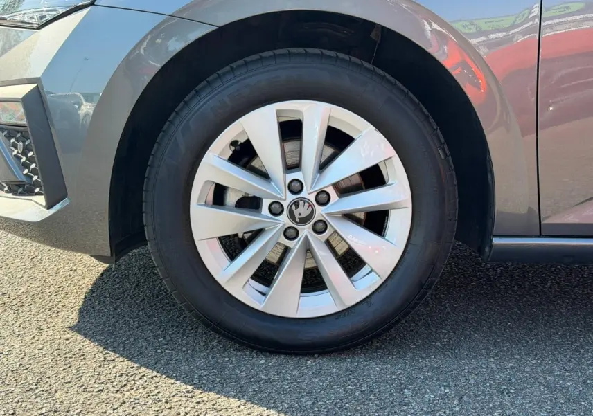 Gros plan sur la roue avant gauche gris métallisé d'une Skoda Scala avec jante alu et logo central visible.