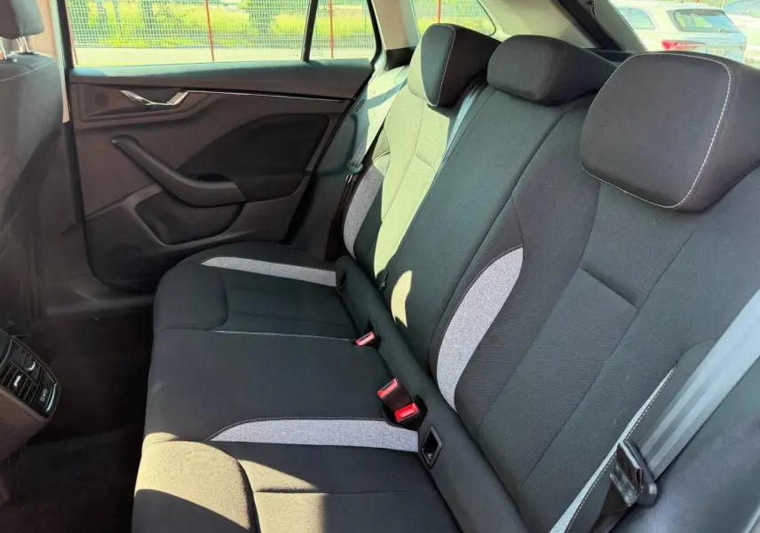 Vue latérale droite de la banquette arrière tissu noir et gris de la Skoda Scala 2025, avec ceintures et appuie-têtes.
