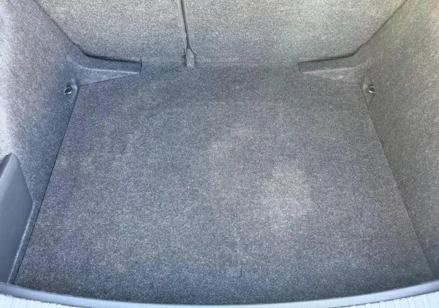 Coffre vide gris vu de dessus d'une Skoda Scala 2025, avec revêtement tissu et fixations Isofix visibles.