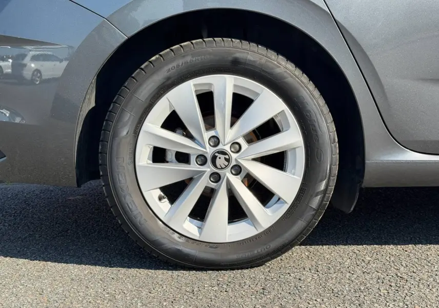 Gros plan sur la roue avant gauche grise d'une Skoda Scala 2025 avec jante alliage et logo au centre.