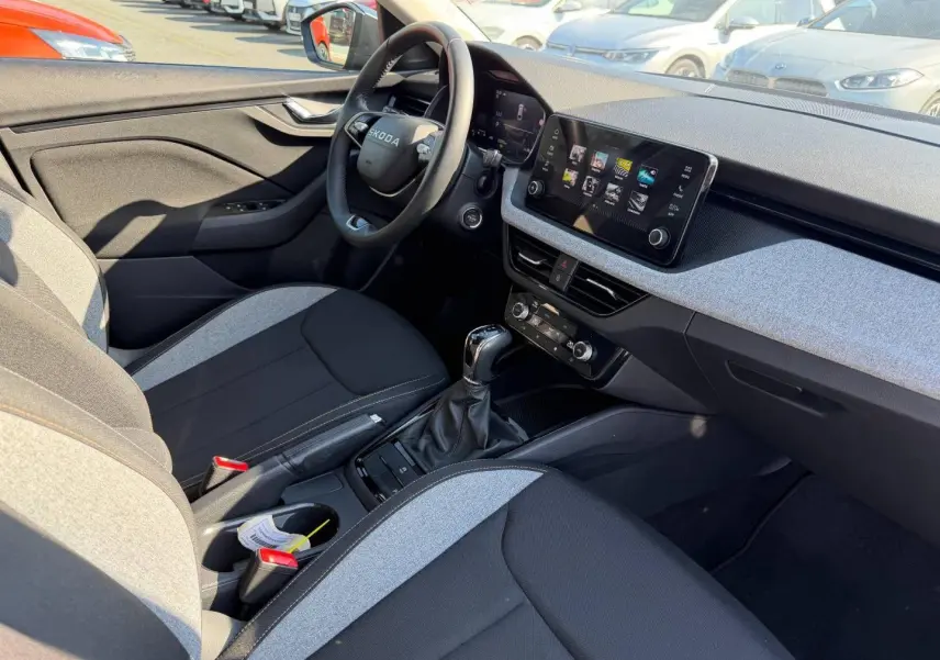 Intérieur avant droit de la Skoda Scala gris, volant cuir multifonction, écran tactile et sellerie bicolore noire et grise.