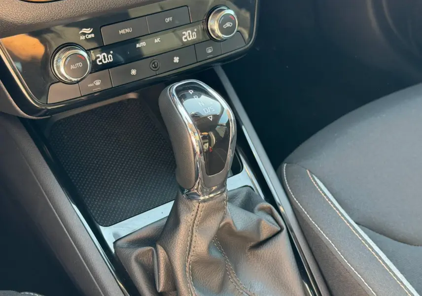 Gros plan sur la console centrale de la Skoda Scala gris, mettant en valeur le levier de vitesse automatique et la climatisation digitale.