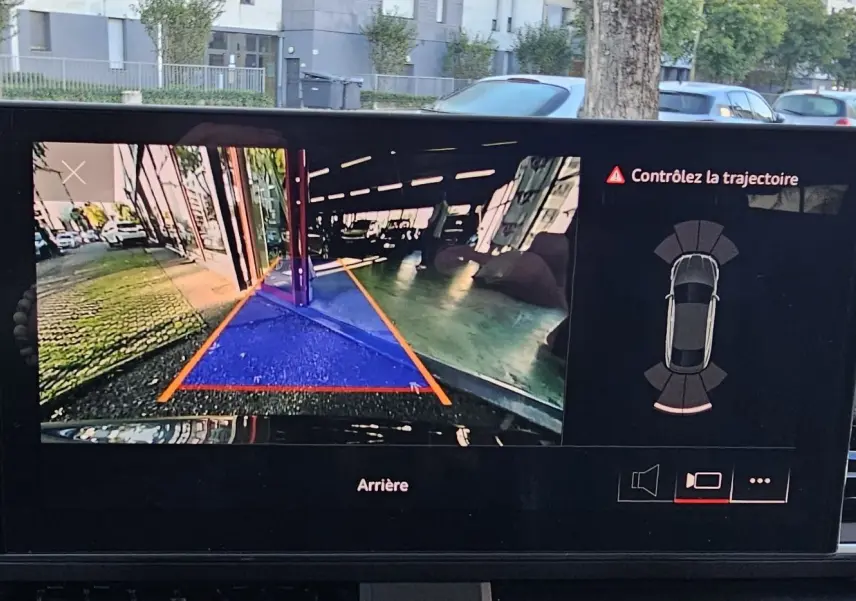 Vue de l'écran intérieur affichant la caméra de recul avec trajectoire assistée sur Audi A5 Sportback gris Daytona.