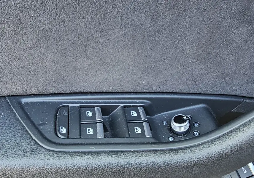 Commande des vitres et réglage des rétroviseurs sur la porte côté gauche d'une Audi A5 Sportback gris Daytona 2022.