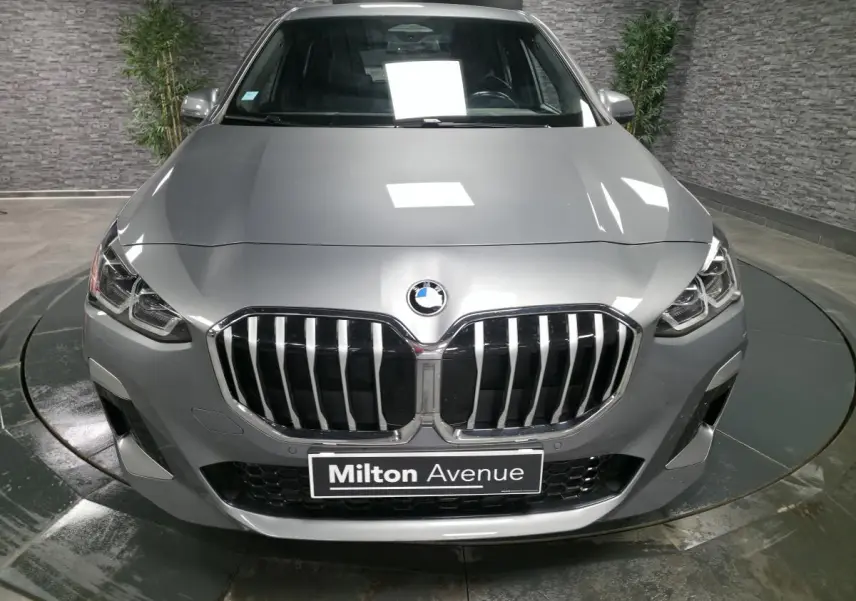 Vue frontale d'une BMW Série 2 218i Active Tourer gris métallisé avec calandre M Sport et phares LED intégrés.