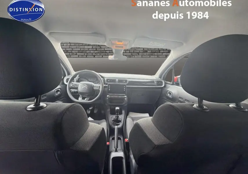 Vue intérieure avant de la Citroën C3 2021 avec tableau de bord moderne et sellerie tissu noire.