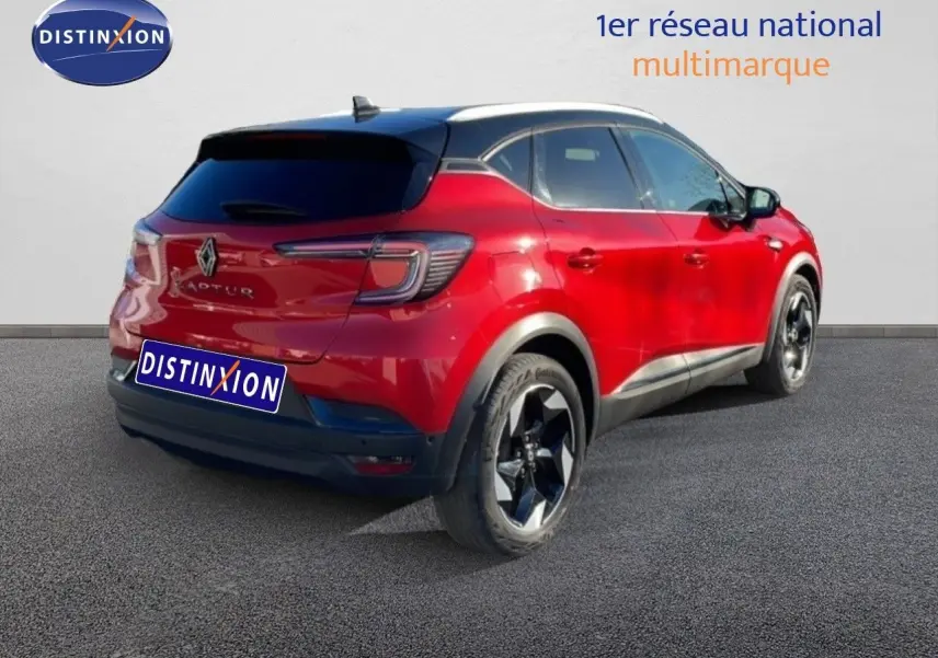 Vue 3/4 arrière droite du Renault Captur rouge Désir Métal avec toit noir et jantes noires brillantes.