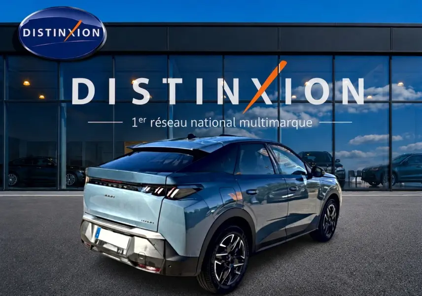 Vue 3/4 arrière droite d’un Peugeot 3008 bleu 2025 avec jantes alu et feux arrière LED, devant un showroom Distinxion.