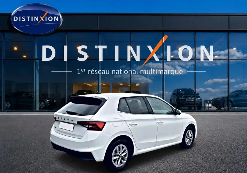 Vue 3/4 arrière droite d'une Skoda Fabia blanche 2025 avec jantes alliage devant une vitrine Distinxion.