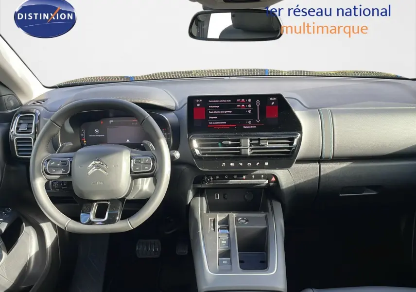 Vue intérieure avant du tableau de bord et du volant gris du Citroën C5 Aircross 2025 avec écran tactile central allumé.