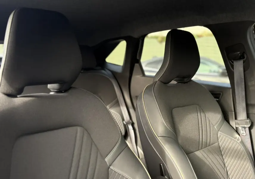 Vue intérieure des sièges avant en tissu noir avec surpiqûres contrastantes du Renault Symbioz E-Tech 2025.