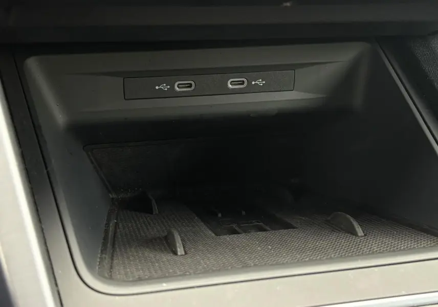 Gros plan sur la console centrale du SEAT Leon noir Minuit, montrant deux ports USB-C intégrés.