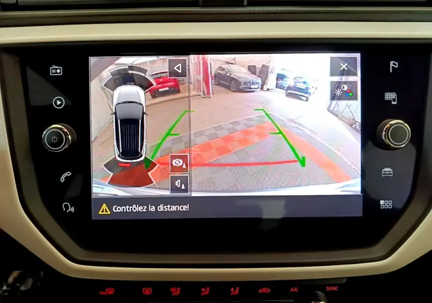 Écran tactile central montrant la caméra de recul et l’alerte de distance du SEAT Arona gris clair, vue intérieure.