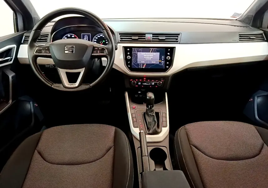 Intérieur avant du SEAT Arona 2019, vue centrée sur le volant cuir alu et l’écran tactile de navigation.