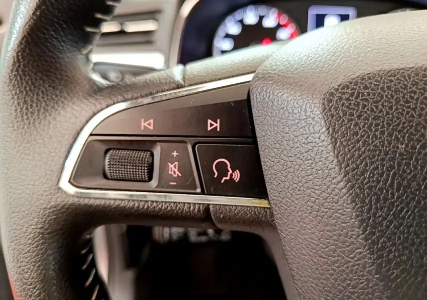 Gros plan sur le côté gauche du volant cuir et alu du SEAT Arona gris clair, avec commandes vocales et volume.