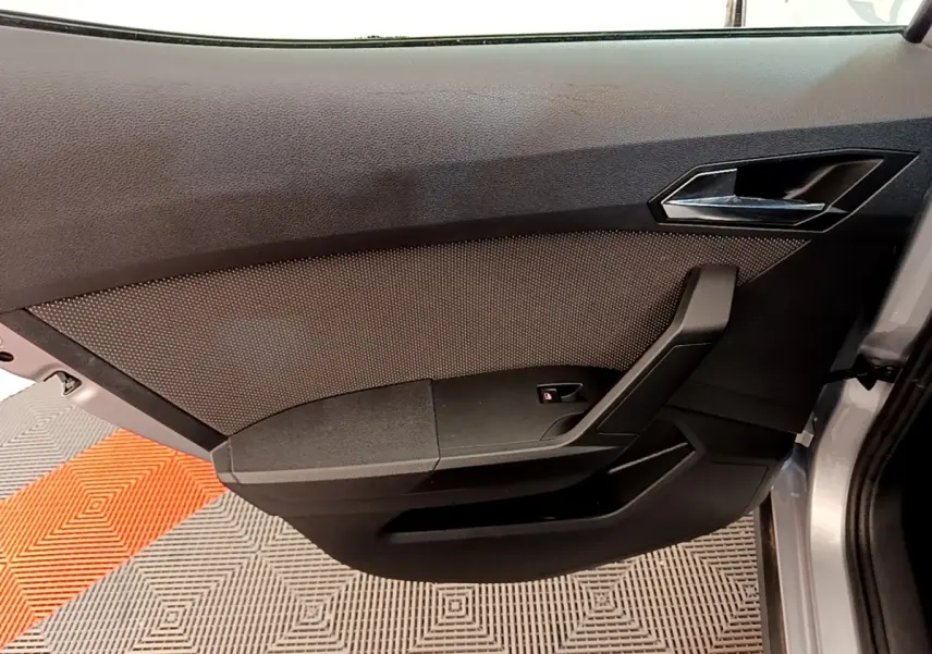 Vue intérieure de la porte avant droite gris clair du SEAT Arona 2019 avec poignée et bouton de verrouillage.