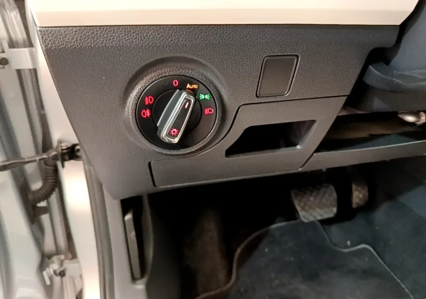 Gros plan sur le bouton de commande des phares dans l'habitacle gris clair du SEAT Arona 2019, côté conducteur.