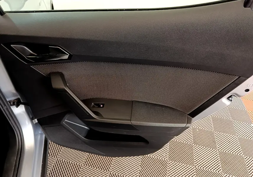 Vue intérieure du panneau de porte côté gauche gris foncé du SEAT Arona 2019 avec texture et poignée intégrée.