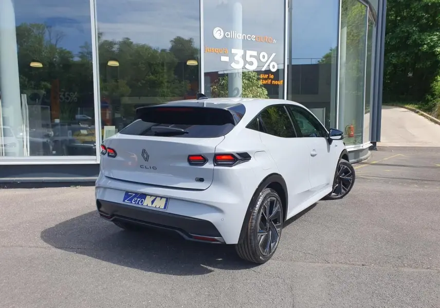 Vue 3/4 arrière droite de la Renault Clio VI hybride gris Rafale avec jantes alliage 18” et feux LED distinctifs.