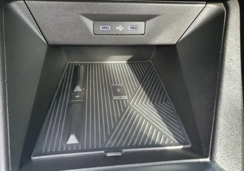 Gros plan sur la zone de rangement avant noire avec deux prises USB-C éclairées dans une Renault Clio VI gris Rafale.