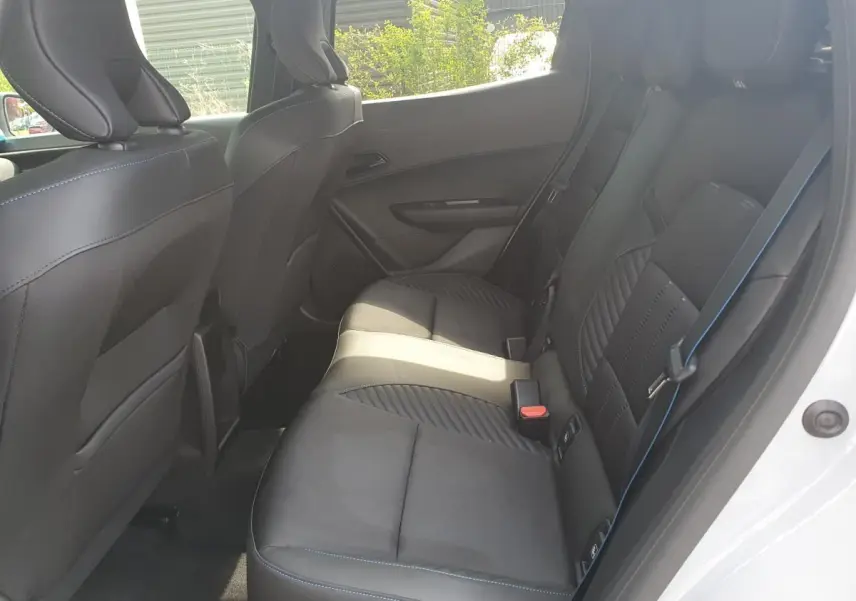 Vue intérieure côté droit des sièges arrière en tissu noir avec surpiqûres bleues d'une Renault Clio VI gris Rafale.