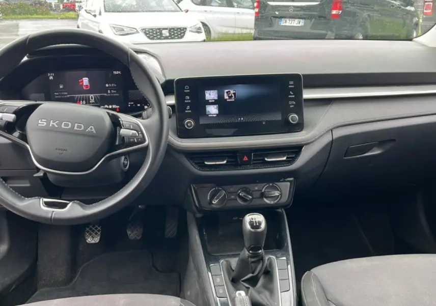 Intérieur avant de la Skoda Fabia noire 2025, vue centrée sur le volant cuir et la console avec écran tactile.