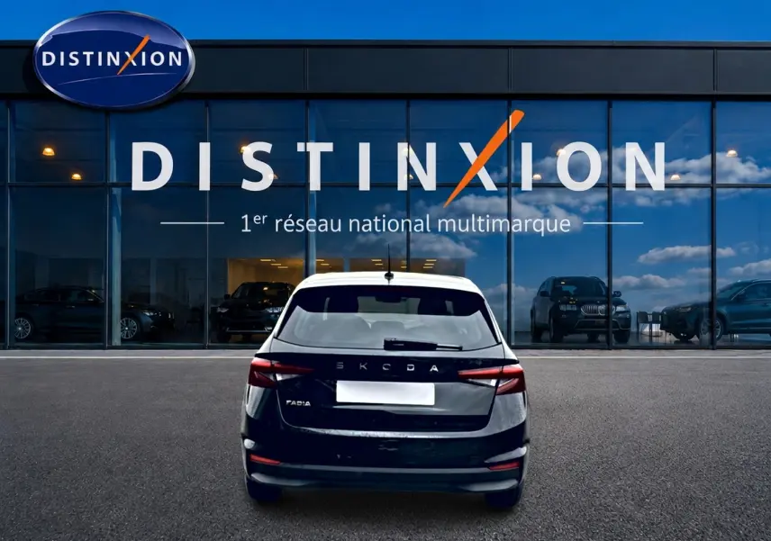 Vue arrière d'une Skoda Fabia noire 2025 garée devant une vitrine avec logo Distinxion.