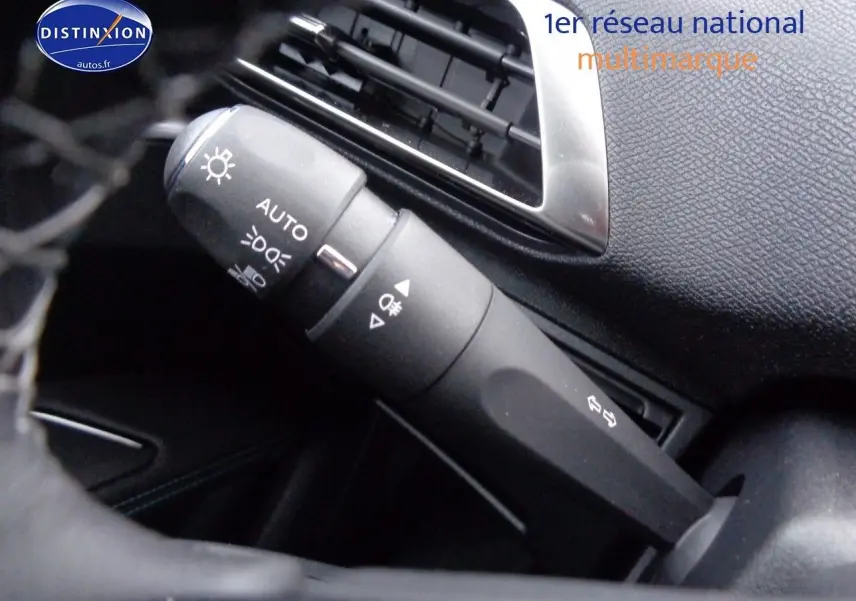 Gros plan sur la commande des phares et clignotants dans l'habitacle noir du Peugeot 3008 2023.