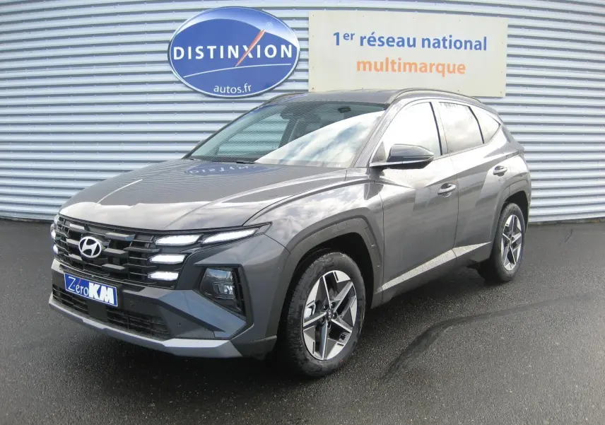 Hyundai Tucson IV PH.2 Style gris Ecotronic en vue 3/4 avant droit, avec calandre distinctive et jantes alliage.
