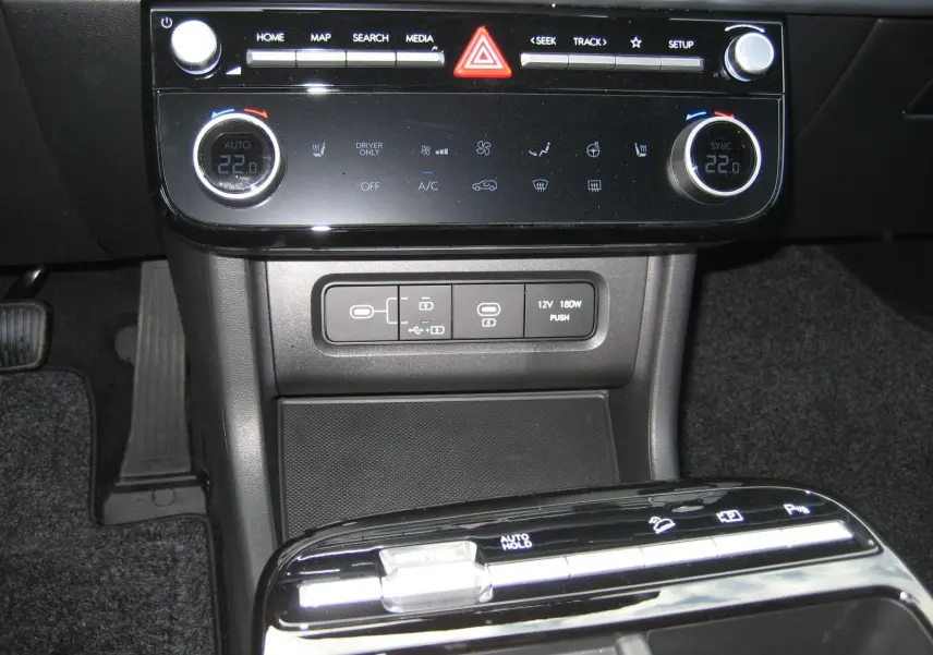 Gros plan sur la console centrale du Hyundai Tucson 2025, avec commandes climatisation et boutons de fonctions électroniques.
