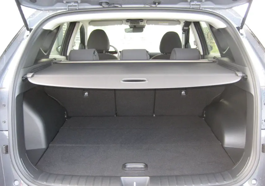 Coffre ouvert d'un Hyundai Tucson 2025 gris Ecotronic, vue arrière montrant la plage arrière et les sièges arrière.