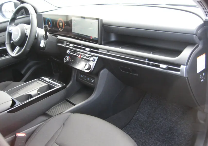 Vue intérieure côté passager du Hyundai Tucson 2025 gris Ecotronic, tableau de bord moderne avec écran tactile panoramique.