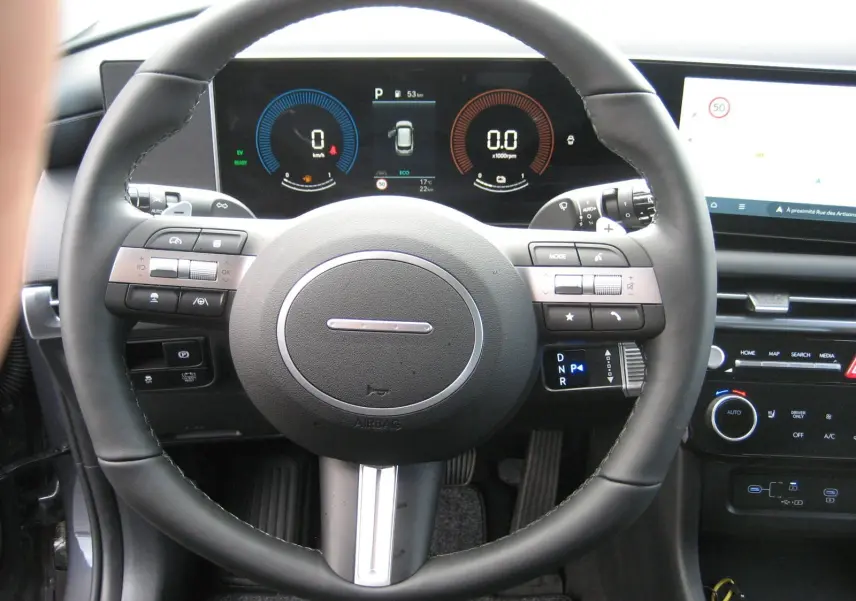 Vue rapprochée du volant multifonction et du tableau de bord numérique du Hyundai Tucson 2025 gris Ecotronic.