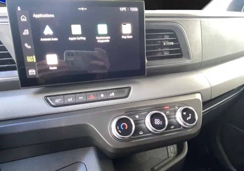 Vue intérieure du tableau de bord du Renault Master 2025, avec écran tactile et commandes de climatisation en gros plan.